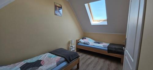 Una pequeña habitación con dos camas y una ventana. en KAPI ośrodek wczasowy w Mielnie, en Mielno