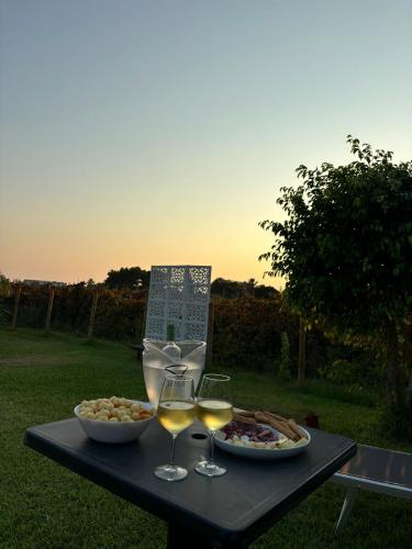 a table with two glasses of wine and food on it at Dammuso Ingarao in Marsala