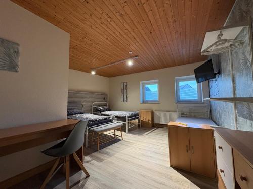 Habitación con 2 camas y escritorio. en Gästehaus Back, en Reinsfeld
