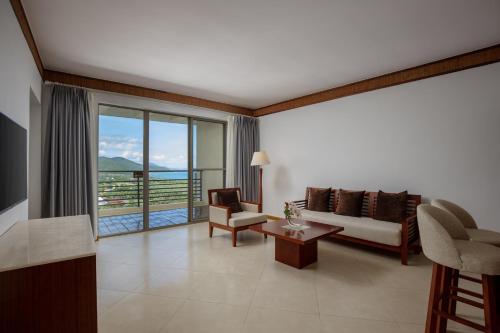 a living room with a couch and a view of the ocean at Sanya Nanshan Leisure Club Seaview Hotel in Sanya