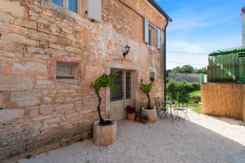 a brick building with two potted trees in front of it at Casa Morosina in Svetvinčenat