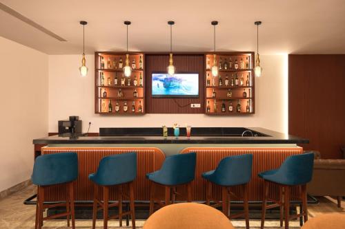 a bar in a restaurant with blue chairs at Best Western Plus Phagwara in Phagwāra