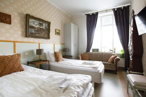 a hotel room with two beds and a couch at Hotelli Verstas in Nakkila