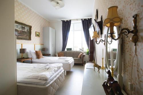 a hotel room with two beds and a couch at Hotelli Verstas in Nakkila