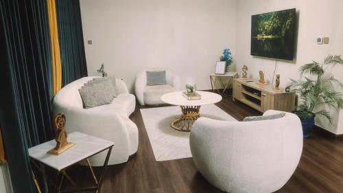 a living room with two white chairs and a table at Luxury Villa in Ras al Khaimah