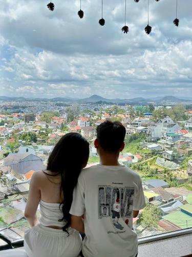 a man and a woman sitting on top of a building at Cosy Hotel & Apartment Dalat in Da Lat