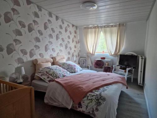 a bedroom with a bed and a tv in it at La petite auberge 
