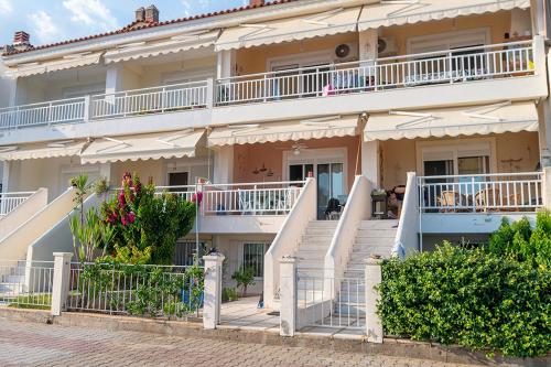 a large building with white balconies on a street at The Beach House Gerakini Chalkidiki in Yerakiní