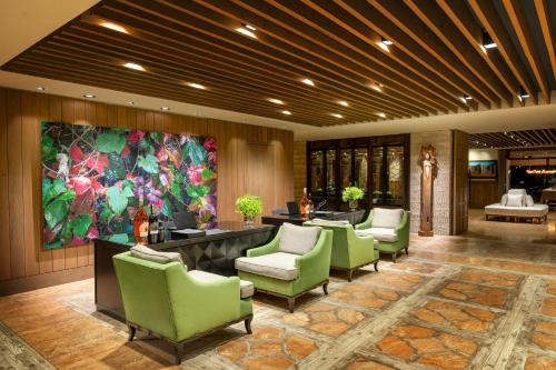a lobby with green chairs and a reception desk at Hotel Caeli in Eceabat