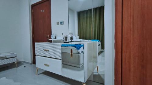 Un baño blanco con lavabo y espejo. en Luxury Villa, en Ras al Khaimah
