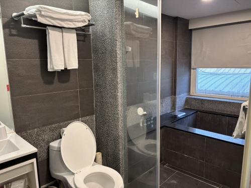 a bathroom with a toilet and a glass shower at CHECK inn Express Taipei Yongkang in Taipei