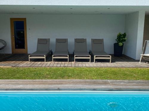 a group of chairs sitting next to a pool at Alpenloft 204, NEU ab 2025 in Forstau