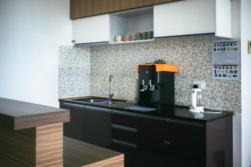 a kitchen with a sink and a coffee maker on a counter at Serene Heights by Evernent in Miri