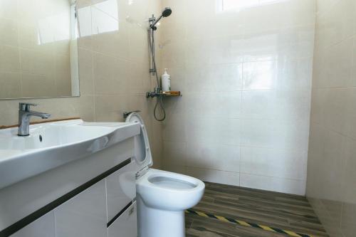 a bathroom with a toilet and a sink and a mirror at Serene Heights by Evernent in Miri