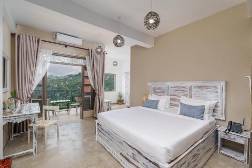 a bedroom with a large bed and a balcony at Kandy City Panorama in Kandy
