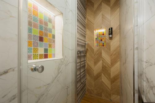 a bathroom with a shower with a mosaic wall at Wellness rezort Jánošíkov dvor in Zázrivá