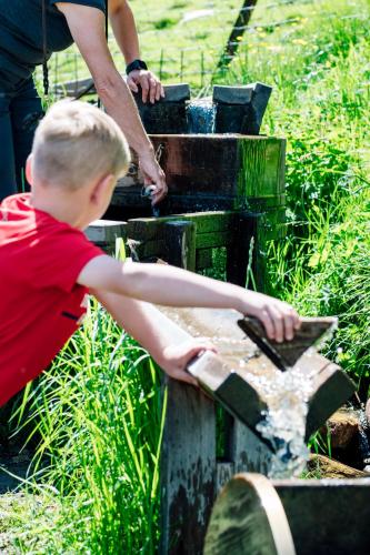 a young boy sitting on top of a bird bath at Hüttendorf Schlögelberger in Sankt Margarethen im Lungau
