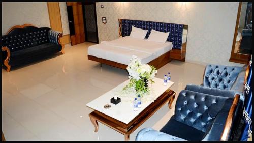 a living room with a bed and a table and chairs at SEA VIEW & SWIMMING POOL HOTEL SGHR ! PURi Air-Conditioned Rooms with Balconies, Restaurant, LIFT & Free Wi-Fi - Best Hotel In Puri in Puri