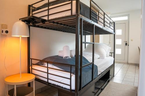 a black bunk bed with white sheets and a stool at Studio Apartment Nittenau Schwandorf - Küche WLAN Modern 2 Personen in Nittenau