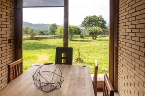 a dining room table with a view of a field at Can Noguer Casa con piscina y jardín in Bescanó