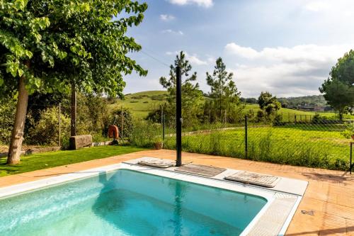 a swimming pool with a view of a garden at Can Noguer Casa con piscina y jardín in Bescanó