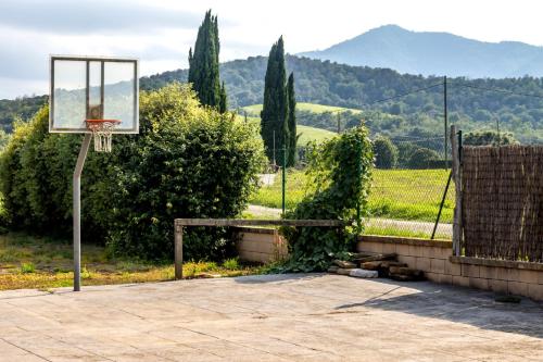 an outdoor basketball hoop with a basket at Can Noguer Casa con piscina y jardín in Bescanó