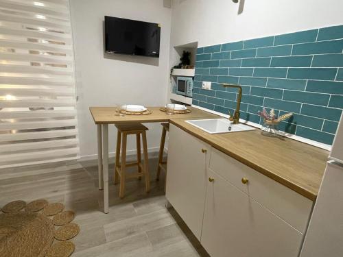 cocina con fregadero y azulejos azules en la pared en Casa Luna, en Almuñécar