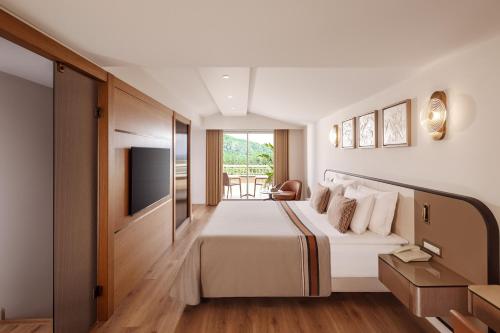 a hotel room with a bed and a television at Akka Antedon Hotel - Premium Ultra All Inclusive in Beldibi
