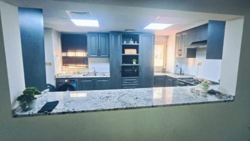 a kitchen with blue cabinets and a marble counter top at Luxury Villa in Ras al Khaimah