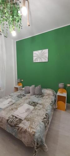 a bedroom with a large bed with a green wall at Casa Linda Rozzano HUMANITAS FORUM ASSAGO M2 MILANO Centro IEO in Rozzano