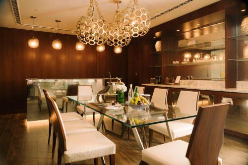 a dining room with a glass table and chairs at Royal Saray Resort in Manama