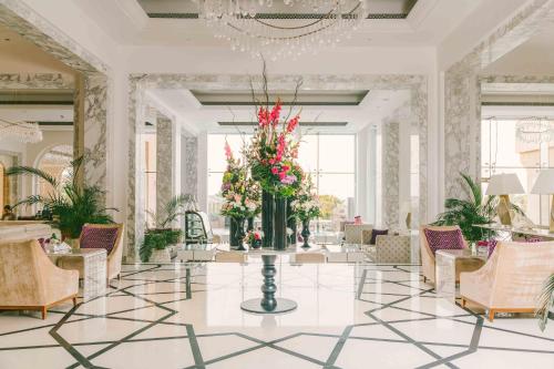 a lobby with a vase of flowers on a table at Royal Saray Resort in Manama