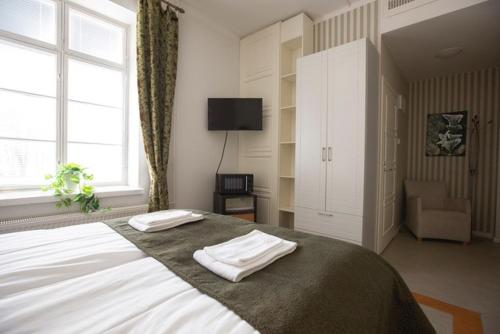 a bedroom with a large bed with two towels on it at Hotelli Verstas in Nakkila