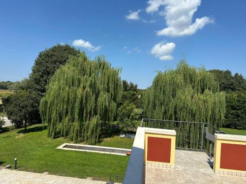 a view of a park with weeping willows and trees at Osteria Locanda Veneta in Mirano