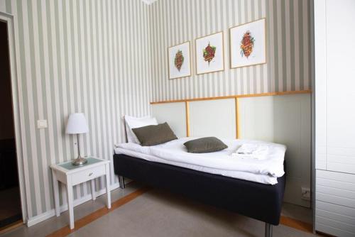 a bedroom with a bed and a table with a lamp at Hotelli Verstas in Nakkila
