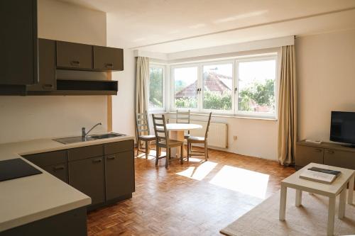 a kitchen with a table and chairs and a window at Guesthouse am See LOOM in Plescherken