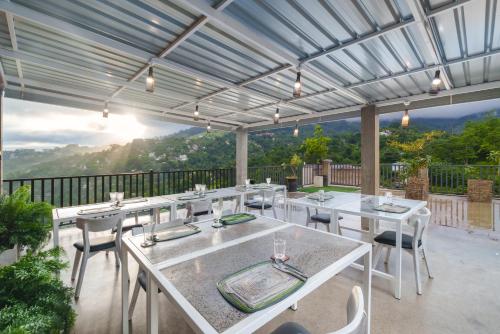 a patio with white tables and chairs with a view at Kandy City Panorama in Kandy
