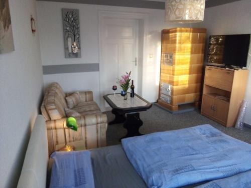 ein Schlafzimmer mit einem Bett, einer Couch und einem Tisch in der Unterkunft Ferienwohnung am Yachthafen in Ueckermünde