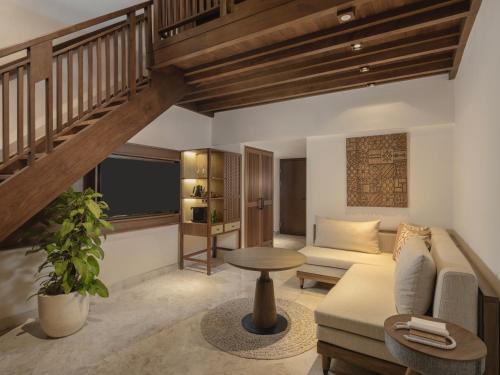 a living room with a staircase and a couch at Paradisus by Meliá Bali in Nusa Dua
