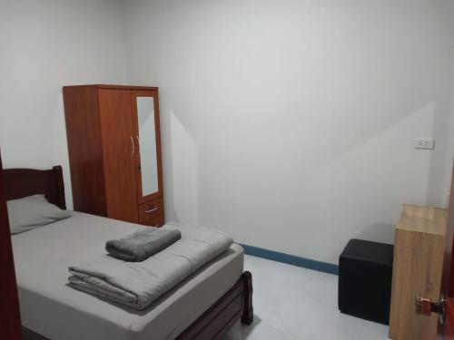 a bedroom with a bed with a mirror and a cabinet at Relax home in Ao Nang 