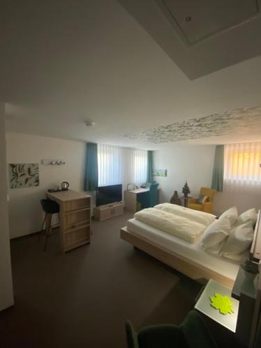 a bedroom with a large bed and a desk at Atrium serviced Apartments and Bungalows in Herzogenaurach