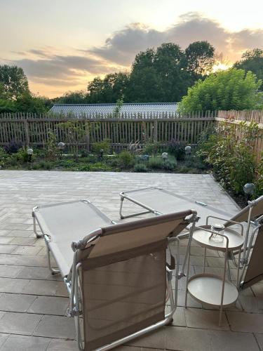 a patio with a table and chairs and a fence at Landhaus Jarnitz in Ralswiek