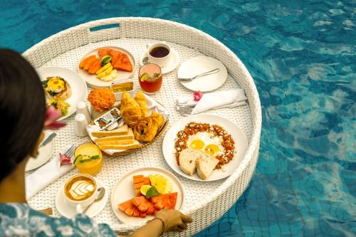 uma mesa cheia de comida ao lado de uma piscina em Sri Phala Resort & Villa em Sanur