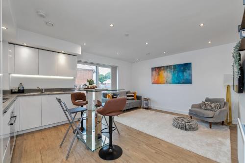 a kitchen with a table and chairs in a room at MODERN & SPACIOUS AIRPORT APARTMENT, Free Parking, Juliet Balcony and Super King Bed in Luton