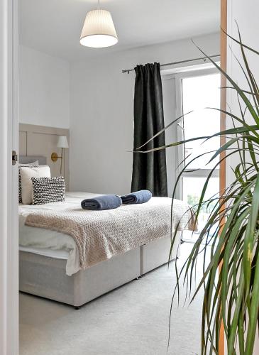 a white bedroom with a bed and a window at MODERN & SPACIOUS AIRPORT APARTMENT, Free Parking, Juliet Balcony and Super King Bed in Luton