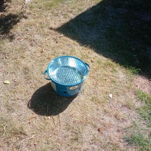 a blue bucket sitting on the grass at logement caravane in Les Journeux