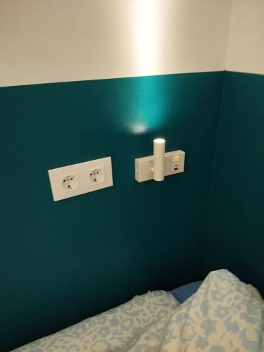 a bedroom with a blue wall with a bed and lights at Onefam Sungate in Madrid