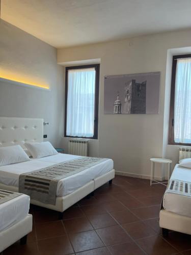 a hotel room with two beds and two windows at Residenza Accademia, MantegnaHotels in Mantova