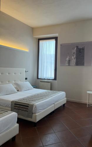 a large bedroom with two beds and a window at Residenza Accademia, MantegnaHotels in Mantova