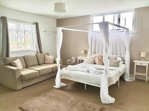 a bedroom with a canopy bed and a couch at Mendip Spring Golf and Country Club in Churchill